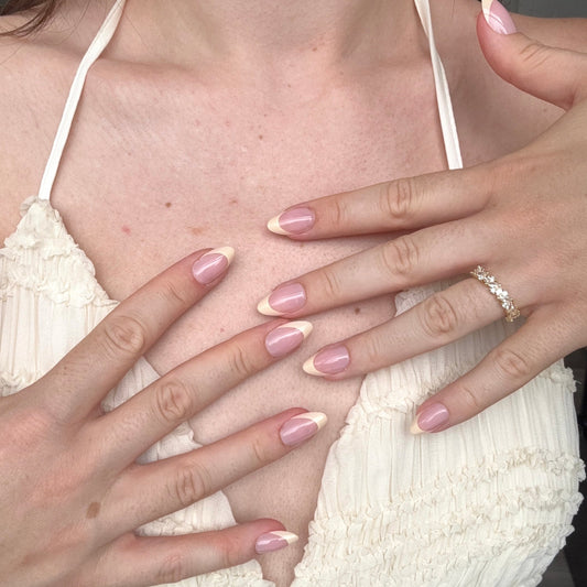 Lifestyle foto van iemand die een butter yellow french manicure draagt, matchend met haar jurk