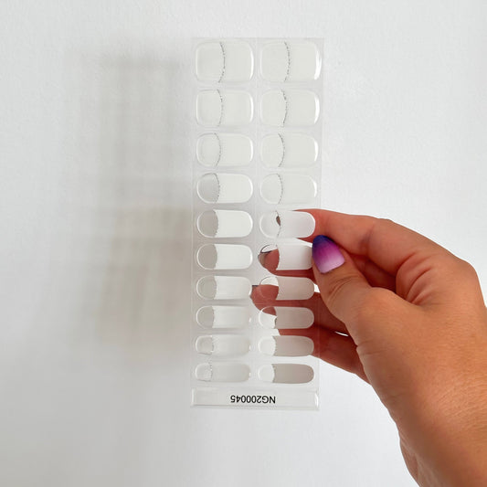 klassieke French manicure gellakstickers. Een transparante basis, witte tips en subtiele zilveren glitterlijn
