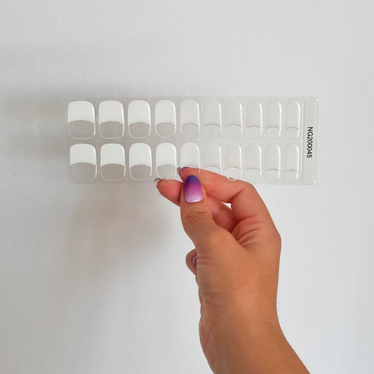 klassieke French manicure gellakstickers. Een transparante basis, witte tips en subtiele zilveren glitterlijn