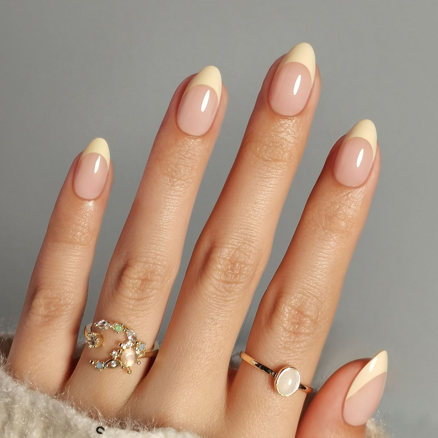 Butter yellow French press-on nagels in almond vorm met een natuurlijke nude basis en zachte botergele French tip