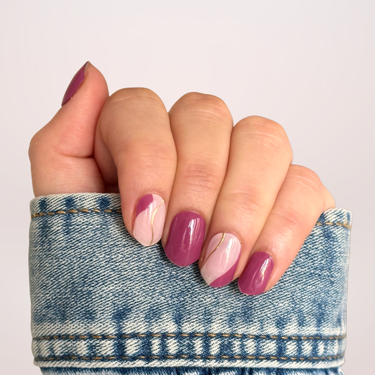 Gellakstickers paarse berry kleur met op sommige nagels een lichte basis erbij met gouden swirl. 