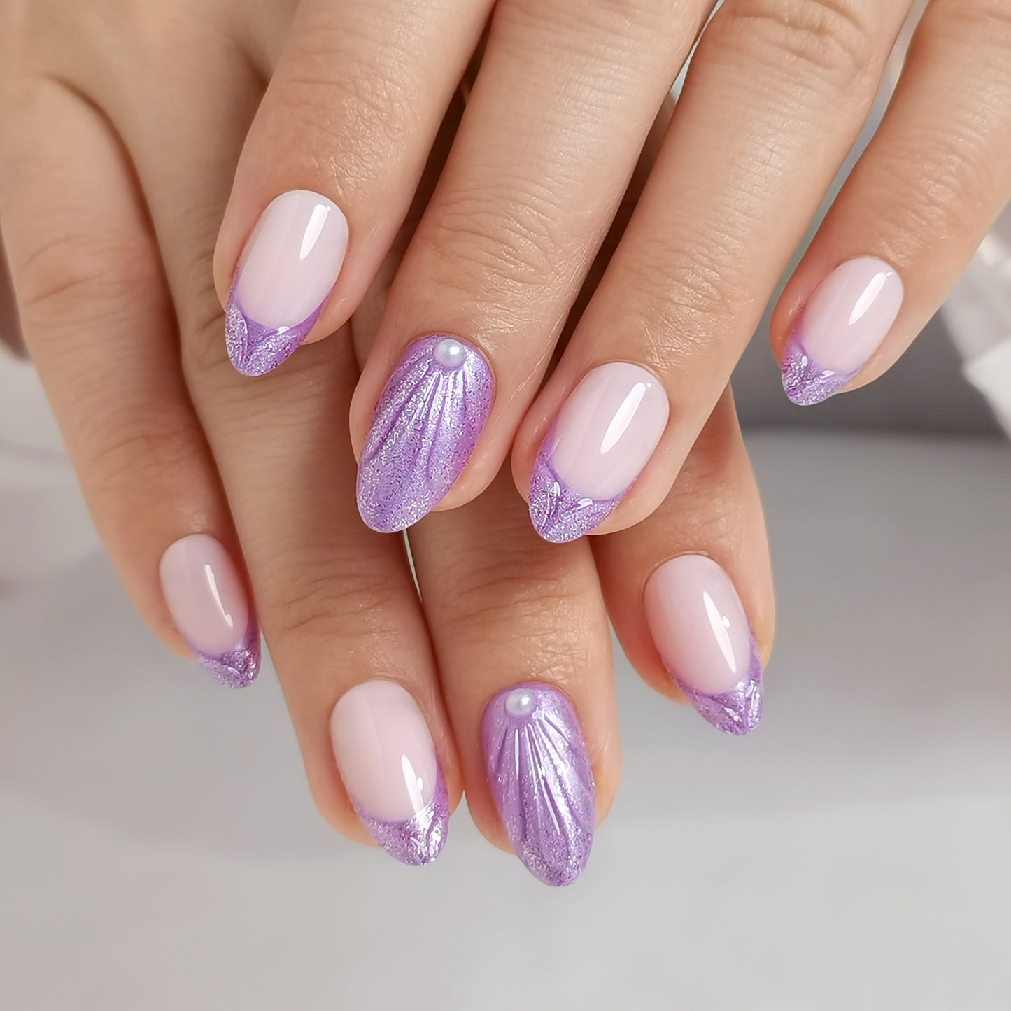 Lila French press-on nagels met shimmer, pareldetail en almond vorm op een natuurlijke nude basis