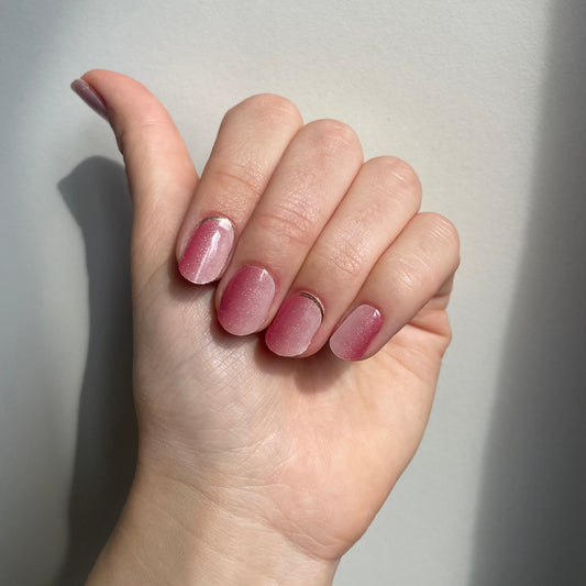 Een roze verticale ombre gellaksticker met glittertjes erdoorheen. Op sommige nagels zit aan de onderkant bij de nagelriem nog een gouden randje